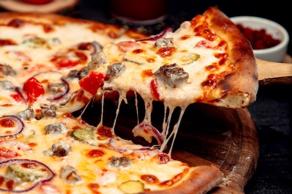 a slice of crispy pizza with meat and cheese